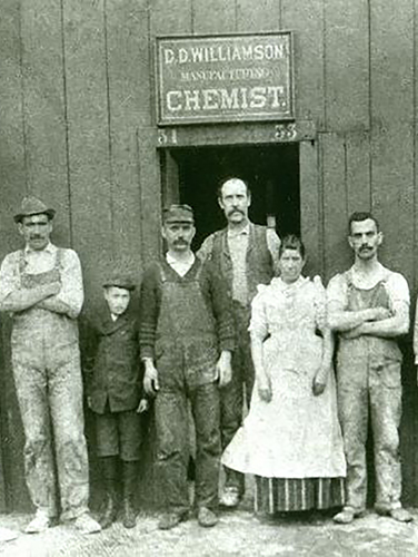 History image of DDW associates in front of a sign late 1800s